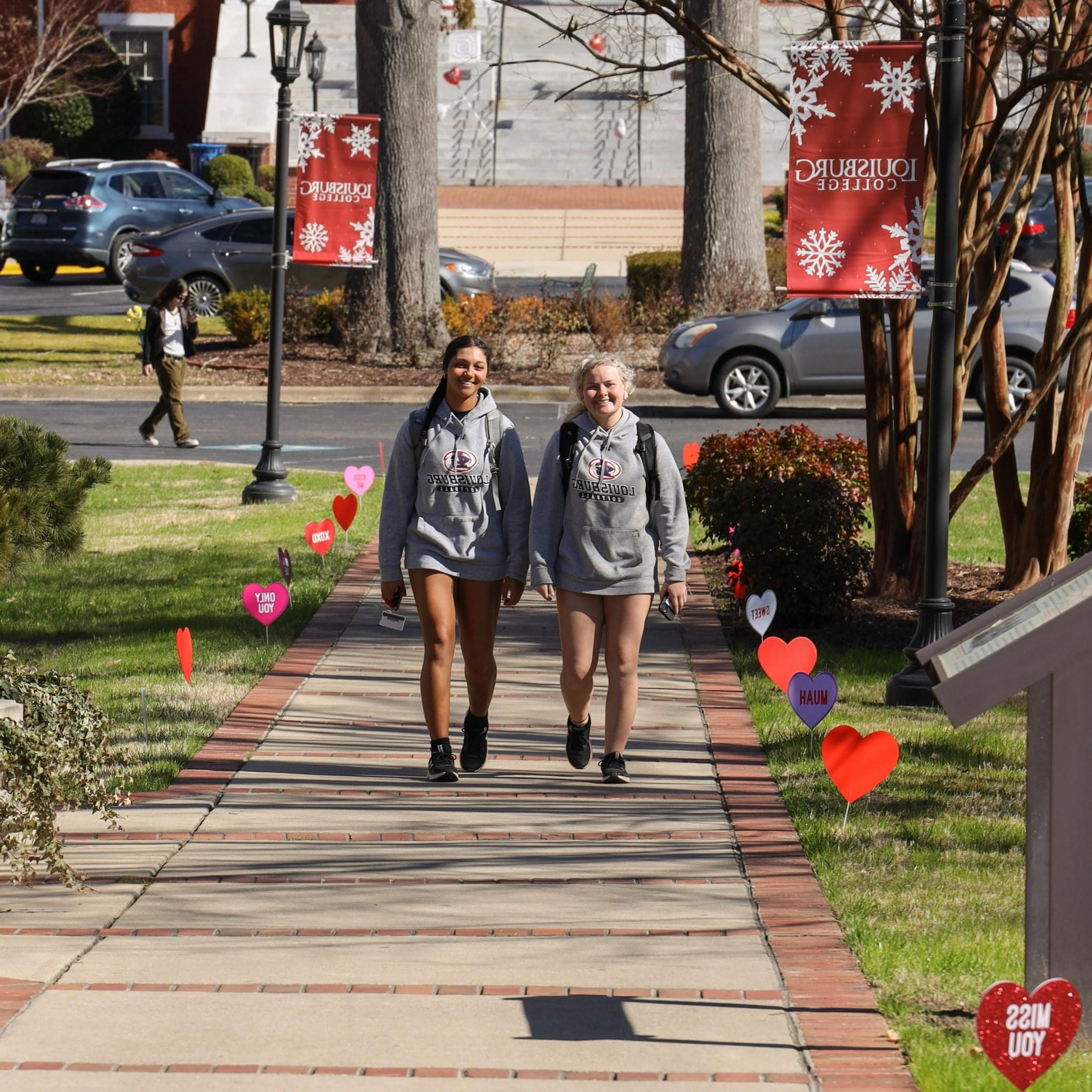 Two femaile students walking on campus.